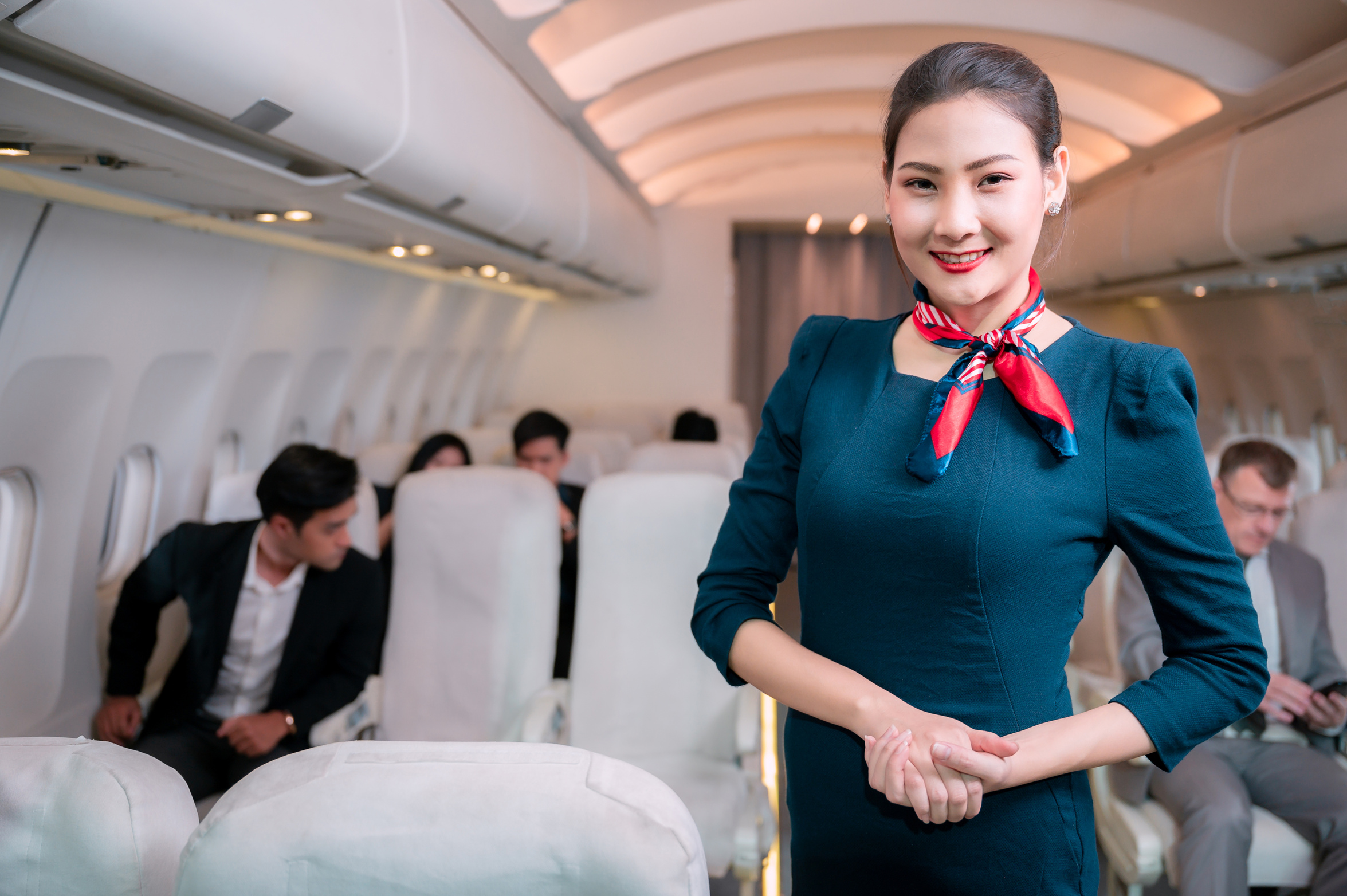 Beautiful flight attendant in an airplane smiling